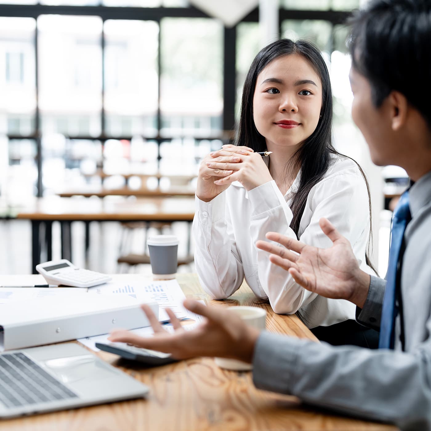 A strategic consultant discussing sitting at table in office, discussing sale and leaseback options to the customer. A strategic consultant discussing sitting at table in office, discussing sale and leaseback options to the customer.